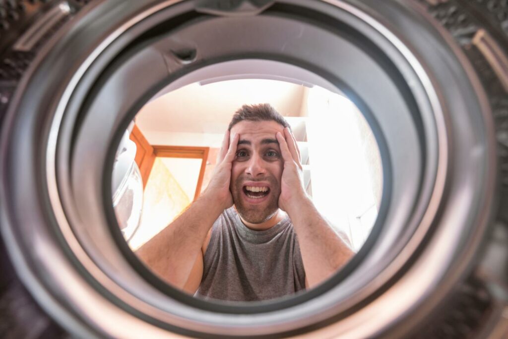 man-looking-stained-bleached-cloth-washing-machine